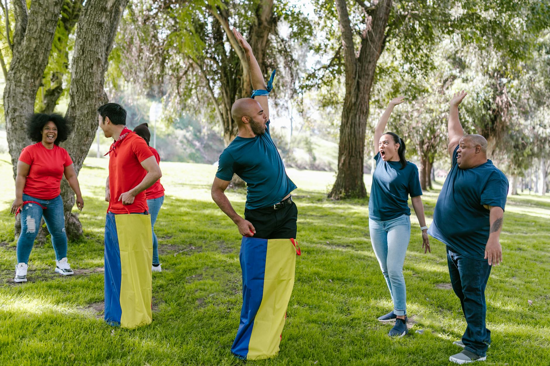Dorośli bawiący się w gry integracyjne w zielonym parku