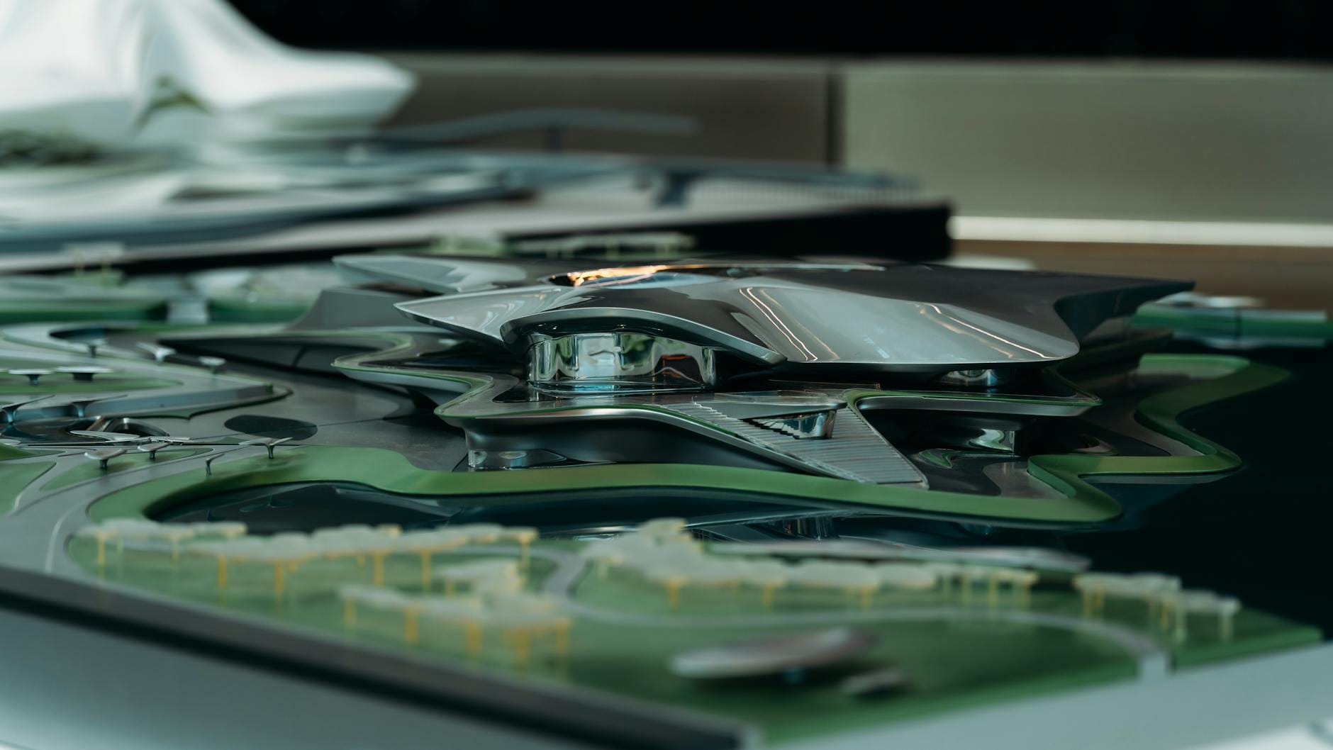 Futurystyczny metaliczny model budynku otoczony zielonym krajobrazem