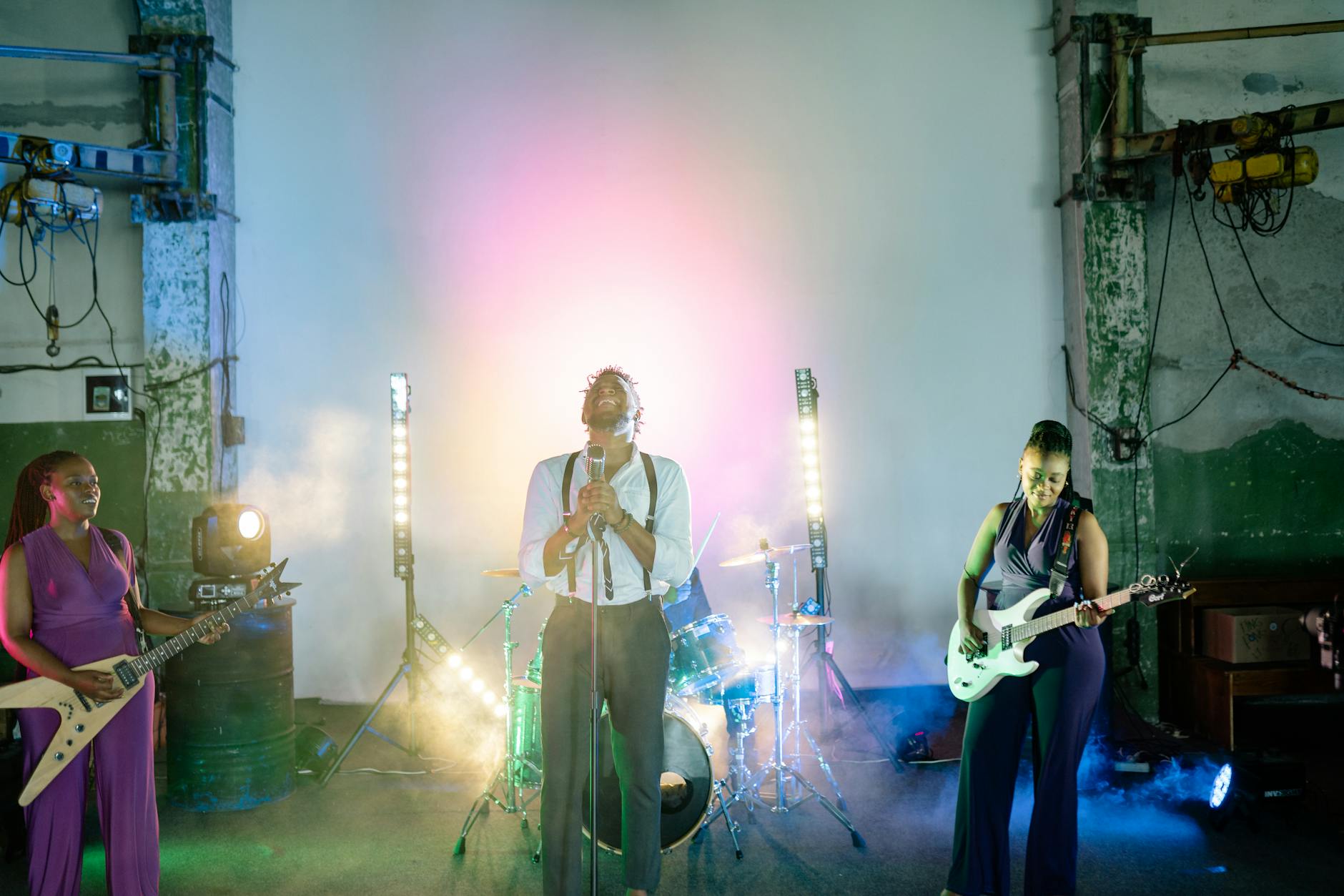 Zespół weselny grający na scenie w kolorowych światłach i dymie