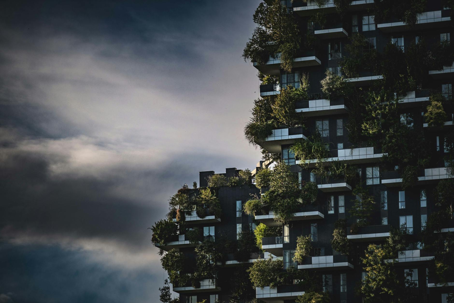 Zielony wieżowiec z roślinnością na elewacji w nowoczesnym mieście