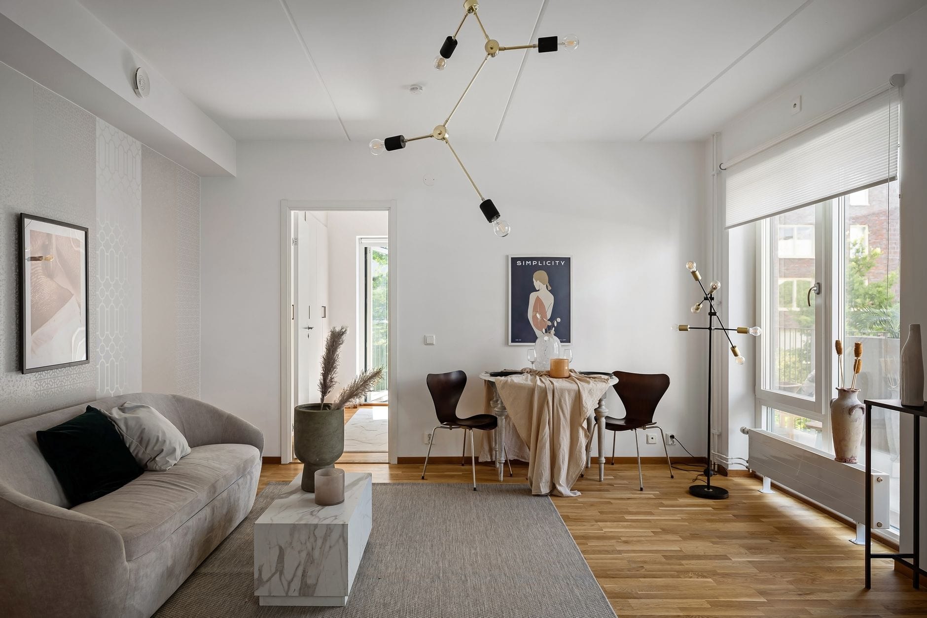 Jasny, nowoczesny salon z minimalistycznymi meblami i dużą ilością światła