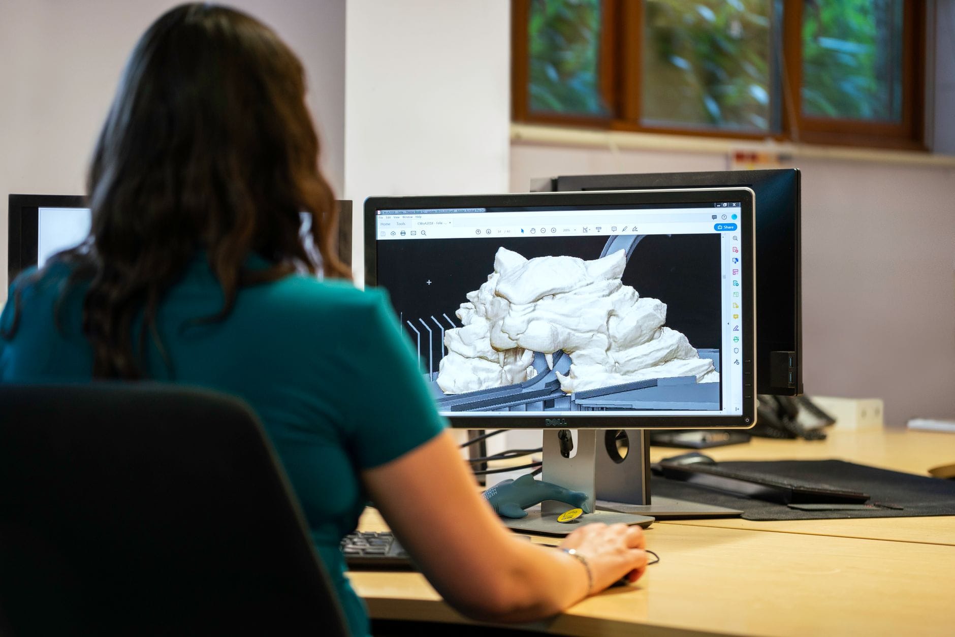 Kobieta w biurze projektuje model 3D w oprogramowaniu CAD
