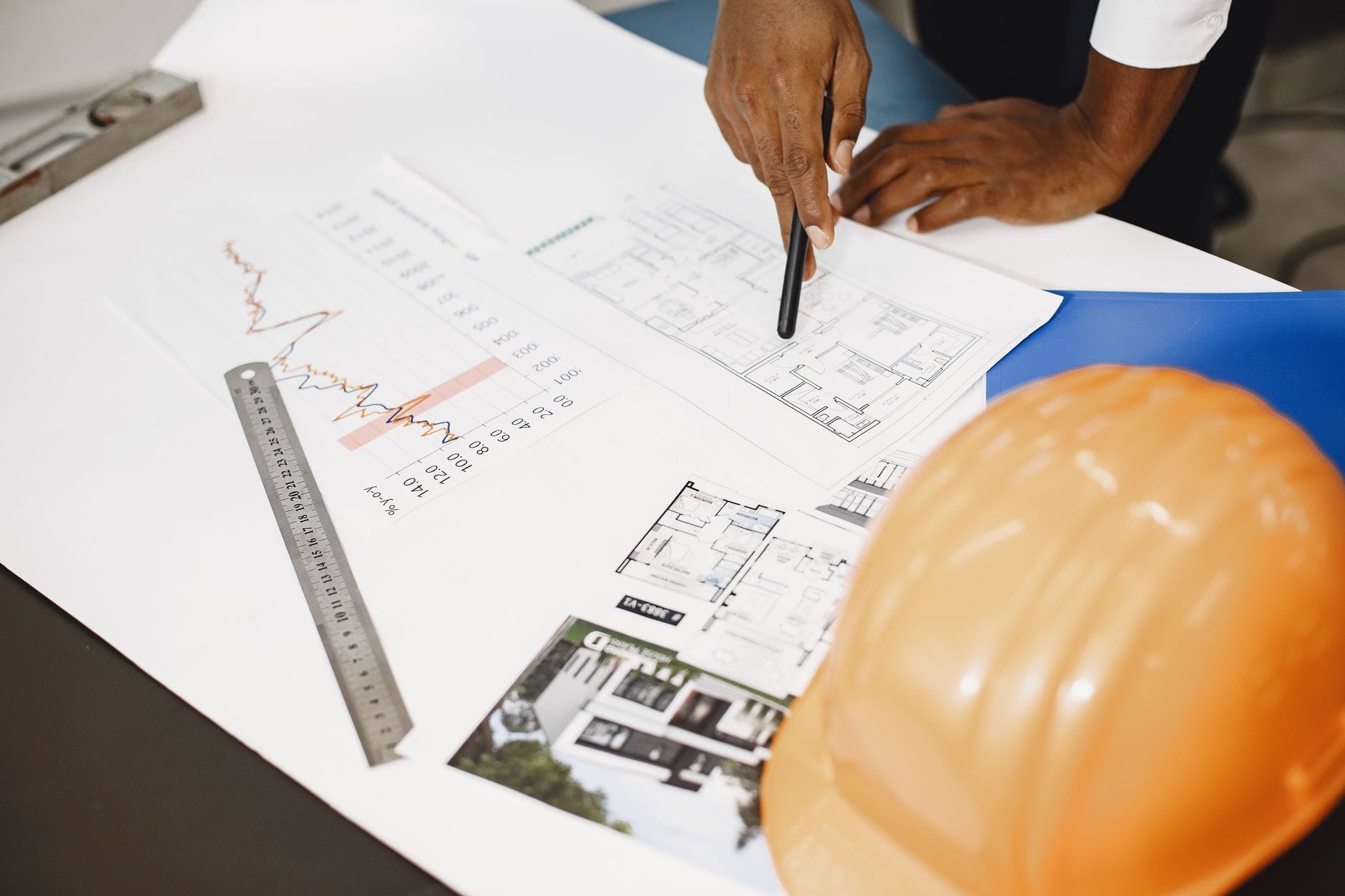 Architekt analizuje plany budynku na biurku z narzędziami projektowymi