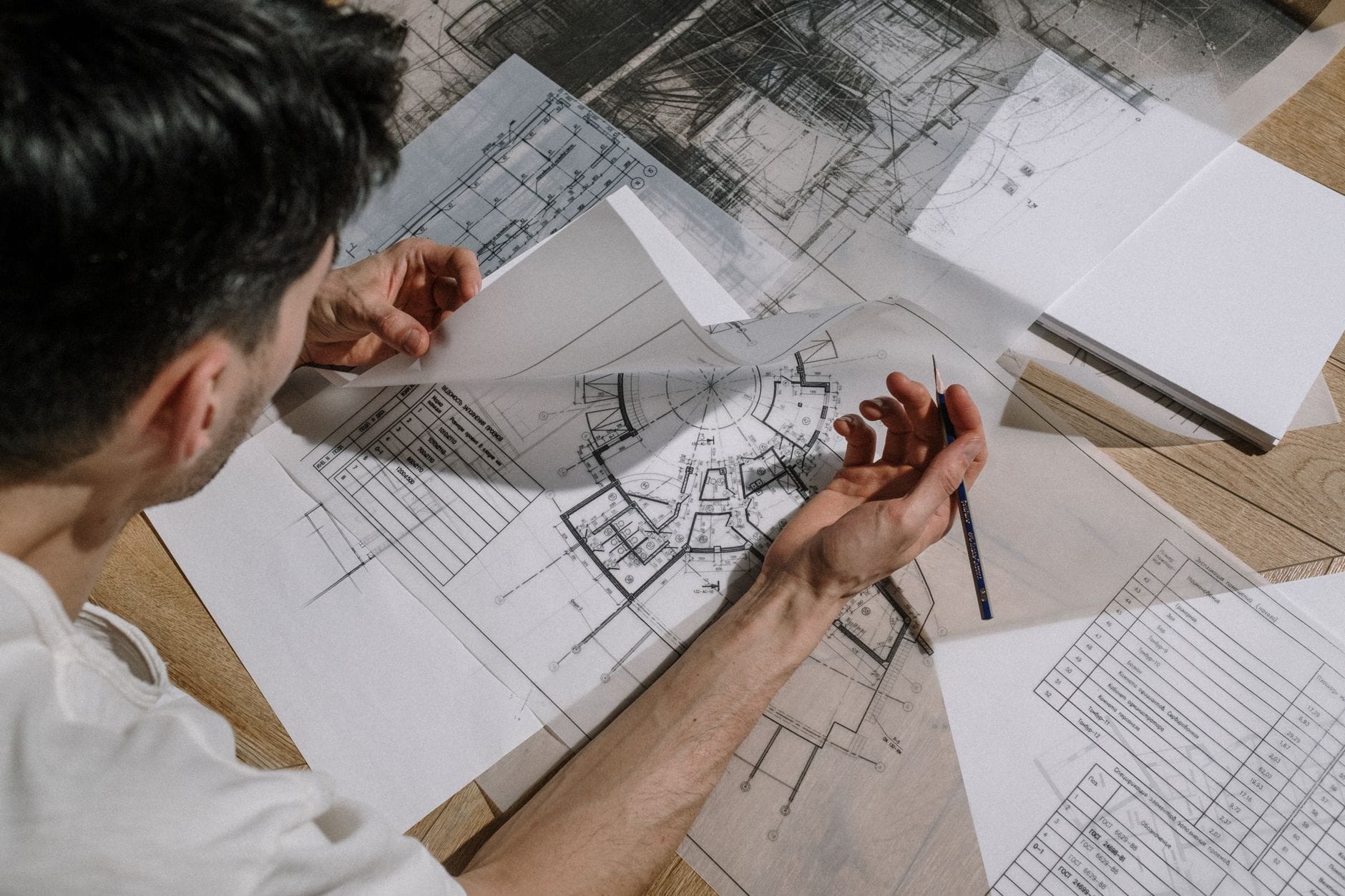 Od szkicu do cyfrowego modelu: proces współczesnego projektowania budynków krok po kroku na przykładzie średniej inwestycji Architekt szkicujący nad szczegółowymi planami budynku